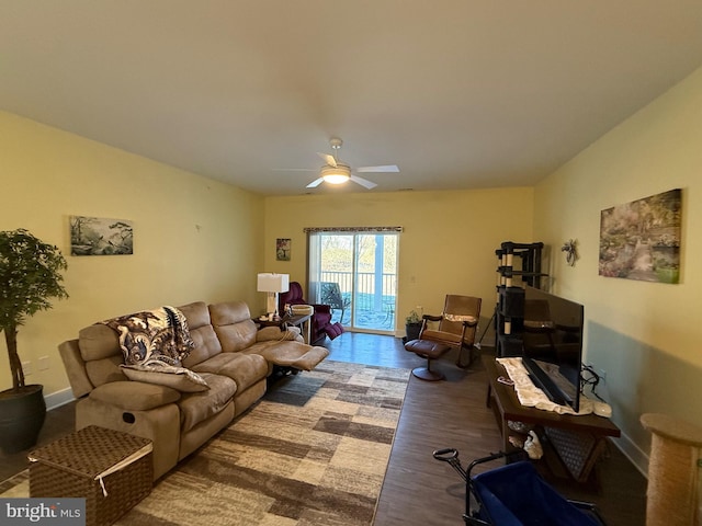 living area featuring ceiling fan, baseboards, and wood finished floors