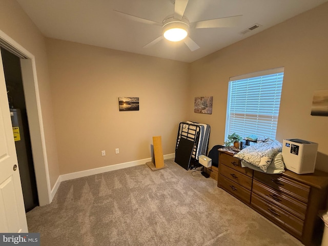 office space featuring ceiling fan, electric water heater, light carpet, visible vents, and baseboards