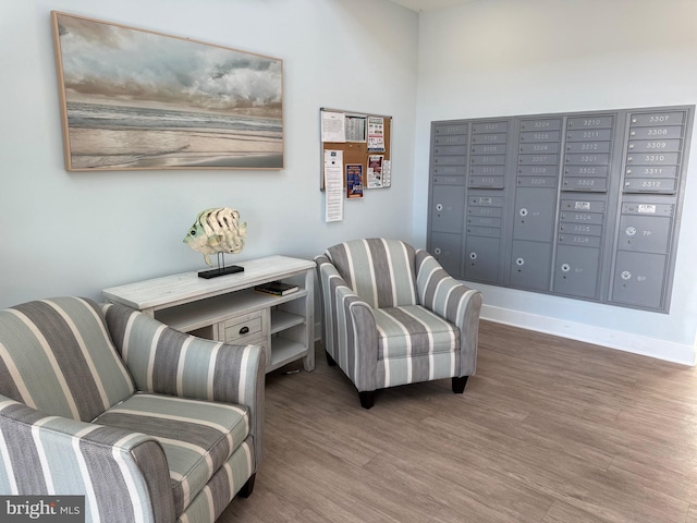 sitting room featuring dark wood finished floors, mail area, and baseboards