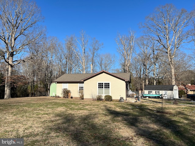 view of side of home with an outbuilding, a yard, and a storage unit