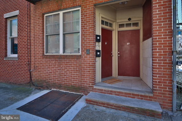 doorway to property featuring brick siding