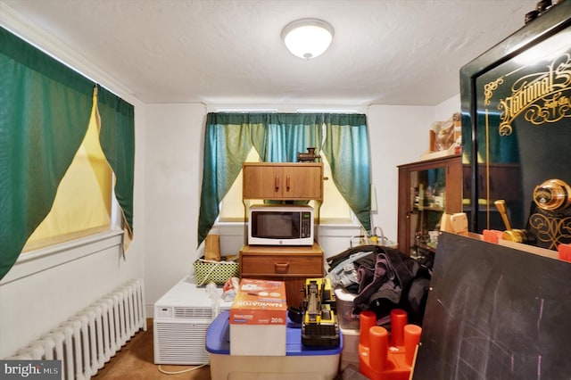 misc room featuring radiator heating unit and a textured ceiling