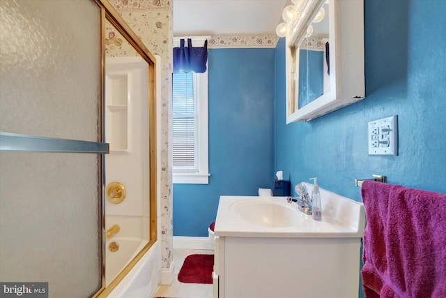 bathroom featuring shower / bath combination with glass door, vanity, and baseboards