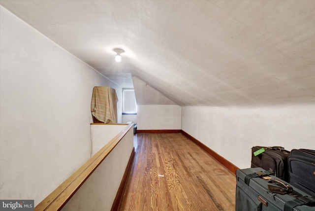 additional living space featuring lofted ceiling, wood finished floors, and baseboards