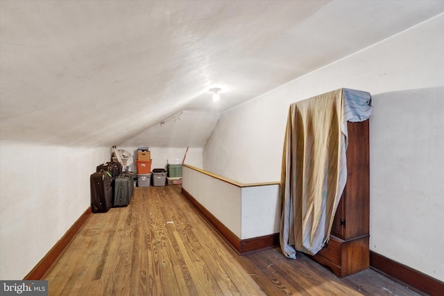 bonus room featuring lofted ceiling, wood-type flooring, and baseboards