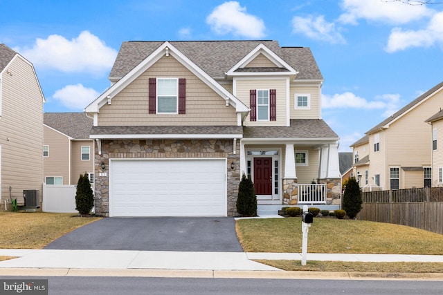 craftsman inspired home with central AC, a front yard, and fence