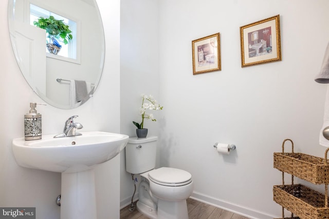 bathroom featuring wood finished floors, toilet, and baseboards