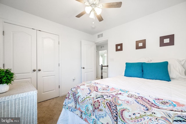 bedroom with ceiling fan, visible vents, a closet, and light colored carpet