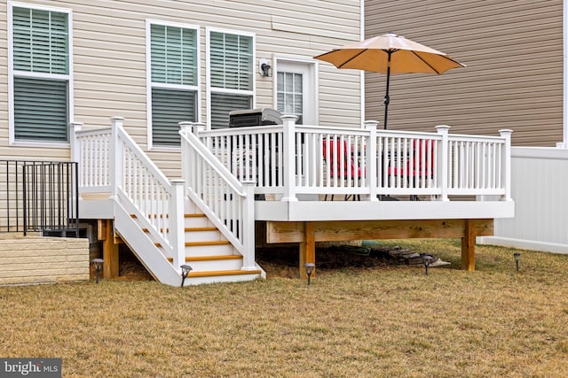 wooden terrace featuring a lawn