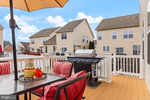 deck featuring a residential view, a fire pit, and grilling area