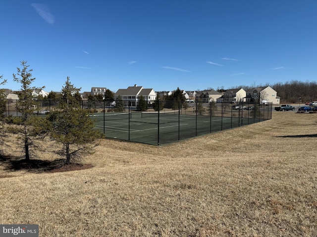 view of sport court with a yard, a residential view, and fence