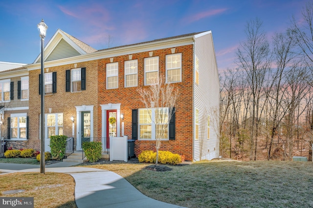 view of front facade featuring brick siding and a front lawn