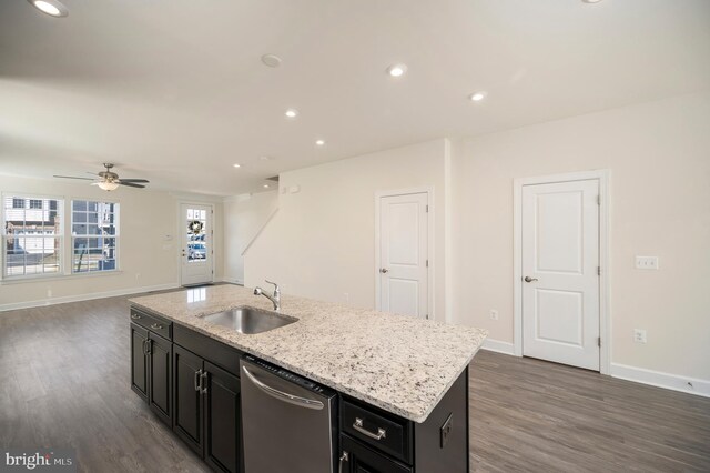 kitchen with dark cabinets, a sink, baseboards, stainless steel dishwasher, and dark wood-style floors