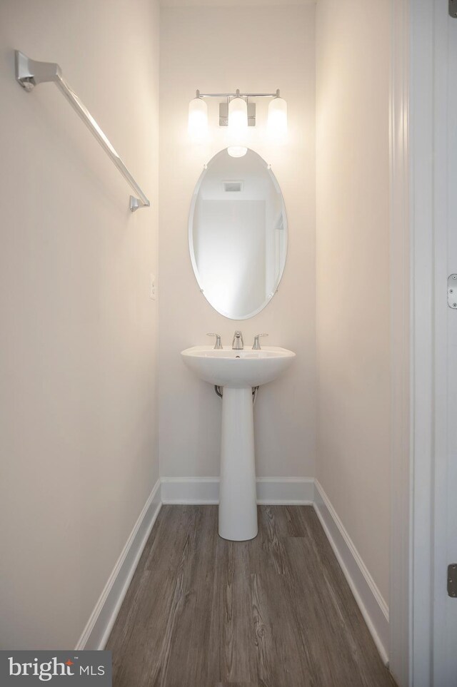 bathroom with visible vents, baseboards, and wood finished floors