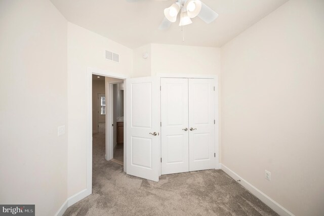 unfurnished bedroom with light carpet, a closet, visible vents, and baseboards