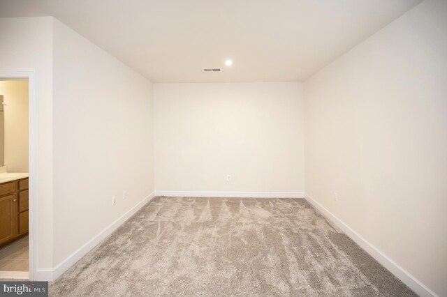 empty room with recessed lighting, visible vents, baseboards, and light colored carpet