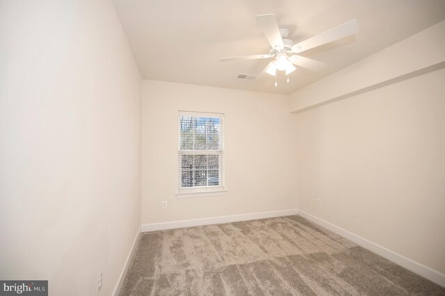 carpeted empty room with ceiling fan, visible vents, and baseboards