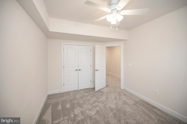 unfurnished bedroom featuring a ceiling fan, a closet, carpet flooring, and baseboards