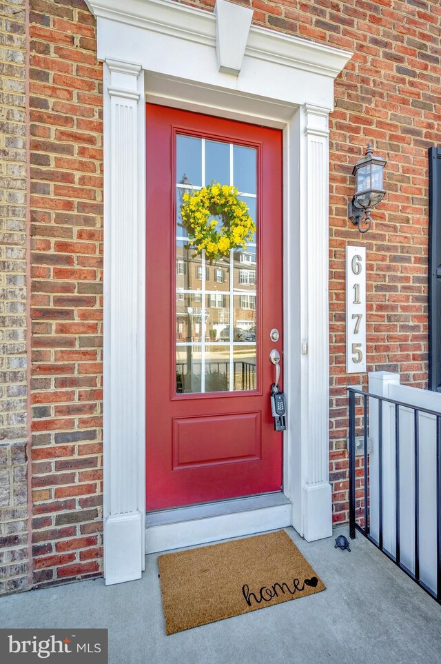 doorway to property featuring brick siding