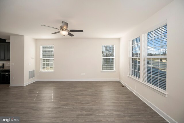 spare room featuring baseboards, visible vents, and a wealth of natural light