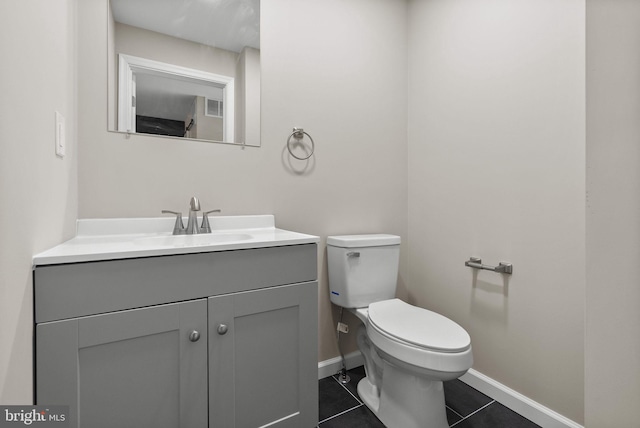 half bathroom featuring tile patterned flooring, toilet, vanity, visible vents, and baseboards