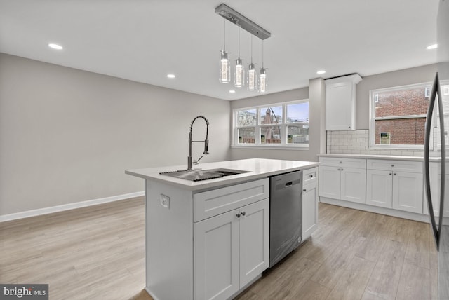 kitchen with a center island with sink, light countertops, stainless steel dishwasher, white cabinetry, and a sink