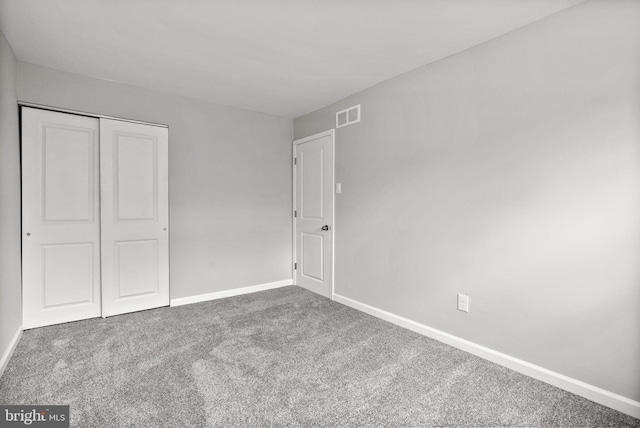 unfurnished bedroom featuring carpet, visible vents, and baseboards