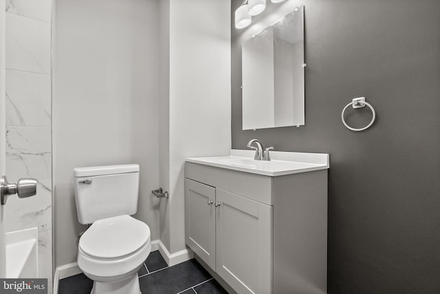 bathroom with baseboards, vanity, toilet, and tile patterned floors