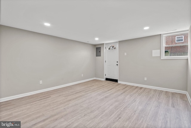 interior space with baseboards, recessed lighting, electric panel, and light wood-style floors