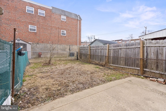 view of yard with a patio area, a fenced backyard, and central air condition unit