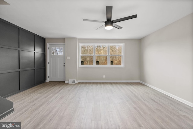 unfurnished living room featuring light wood-style floors, ceiling fan, visible vents, and baseboards