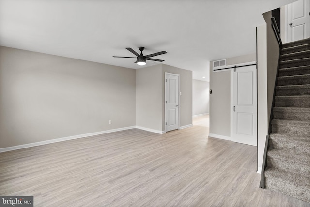 unfurnished living room featuring visible vents, a ceiling fan, baseboards, stairway, and light wood-type flooring