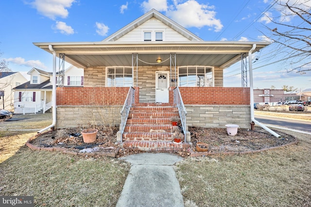 view of front of home with a porch and brick siding