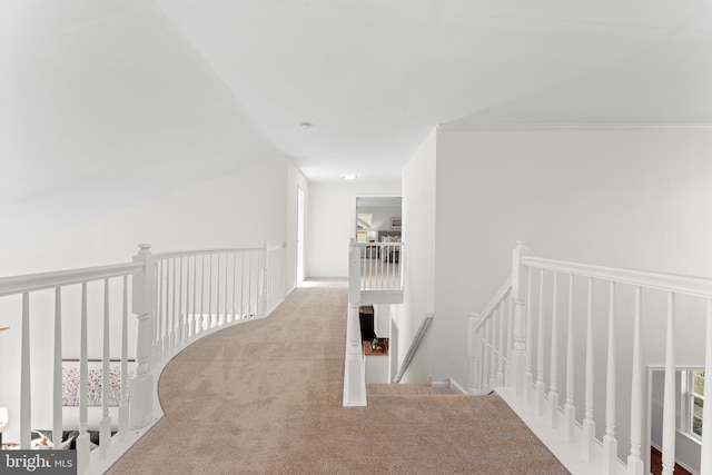 corridor featuring carpet flooring and an upstairs landing