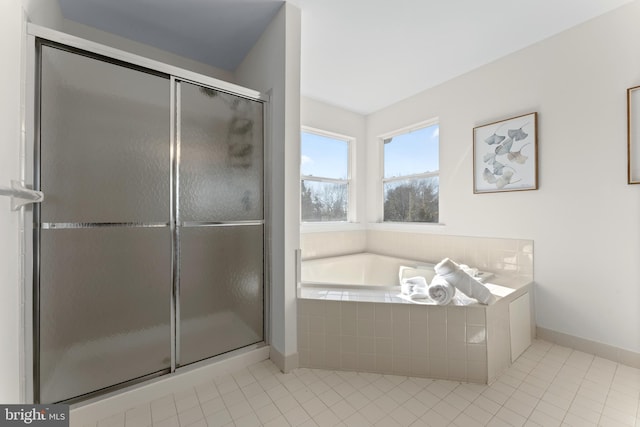 full bath with a garden tub, tile patterned flooring, baseboards, and a stall shower