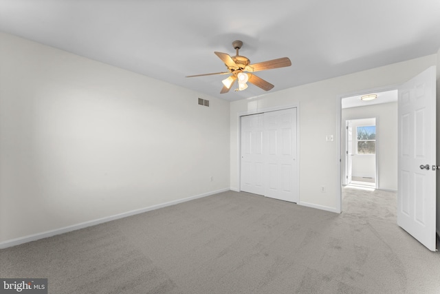 unfurnished bedroom with light carpet, baseboards, visible vents, ceiling fan, and a closet