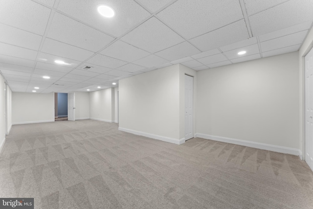 finished basement featuring a drop ceiling, recessed lighting, light carpet, visible vents, and baseboards