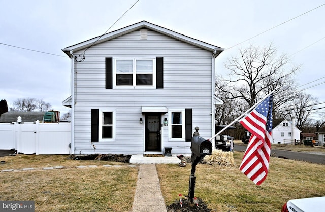 traditional home with fence and a front lawn