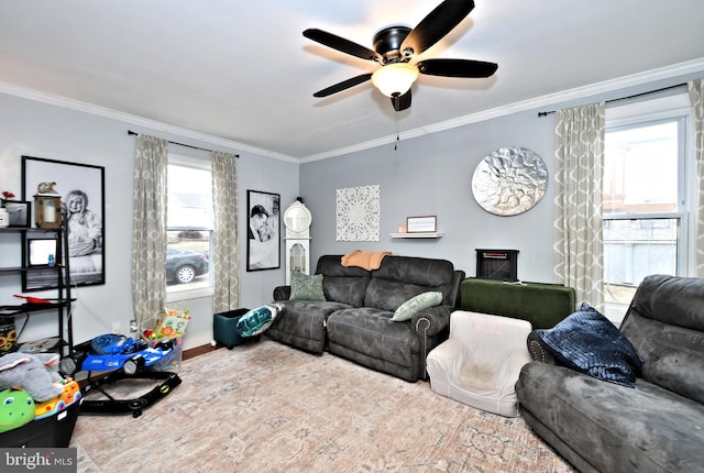 living room with ornamental molding, plenty of natural light, and a ceiling fan