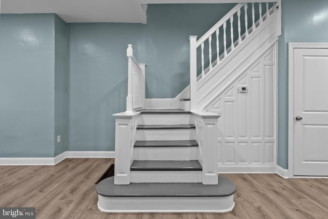 stairway featuring wood finished floors and baseboards