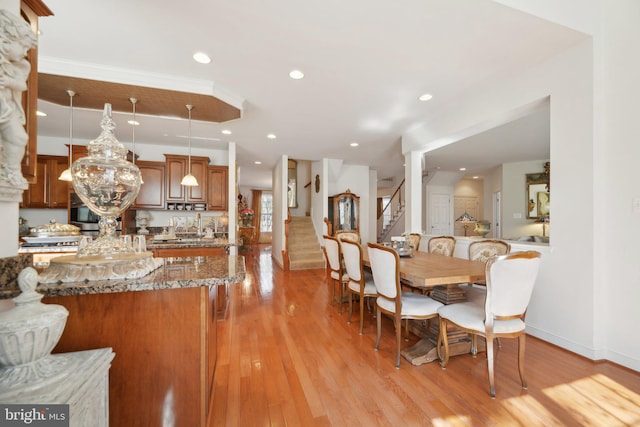 dining space featuring stairs, light wood finished floors, baseboards, and recessed lighting