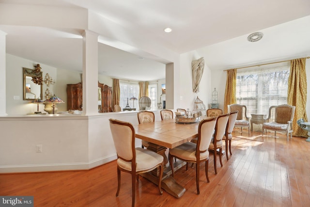 dining room featuring hardwood / wood-style flooring, baseboards, ornate columns, and recessed lighting