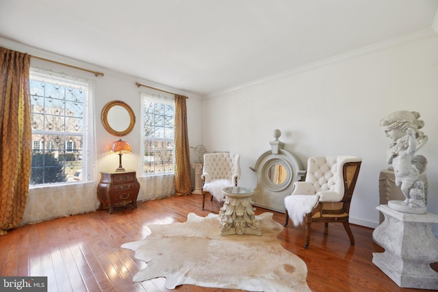 sitting room with ornamental molding and hardwood / wood-style flooring