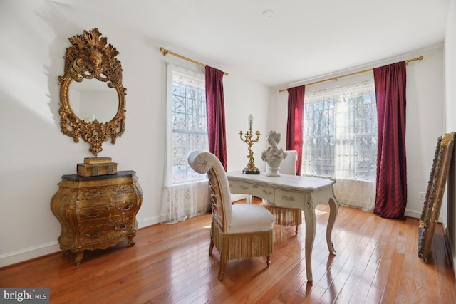 dining area featuring a wealth of natural light, baseboards, and light wood finished floors