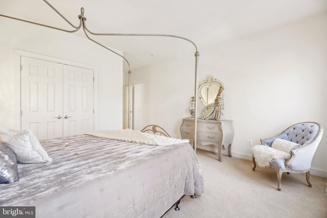 carpeted bedroom with baseboards and a closet