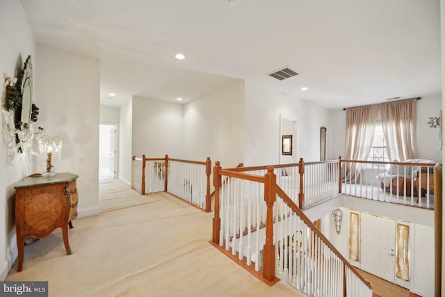 corridor featuring recessed lighting, visible vents, light carpet, and an upstairs landing