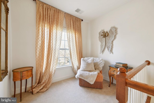 living area featuring carpet floors, visible vents, and baseboards