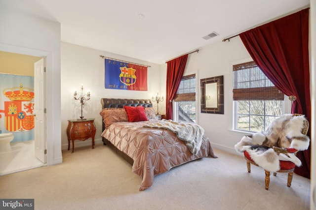 bedroom featuring ensuite bath, carpet flooring, visible vents, and baseboards