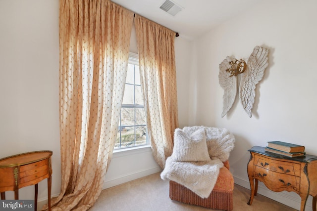 sitting room with carpet floors, visible vents, and baseboards