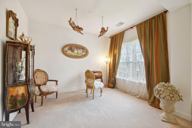 living area with carpet, visible vents, and baseboards